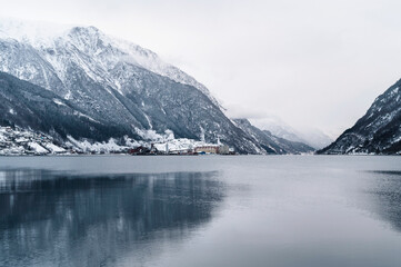 Fototapeta na wymiar Odda, Norway - January 08 2022: City Odda and Hardangerfjord in Norway during winter with snow