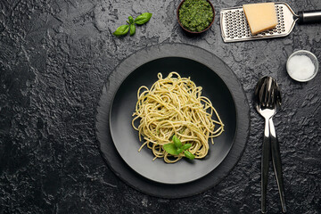 Plate of tasty pesto pasta on dark background