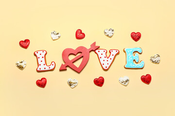 Word LOVE and different heart shaped cookies on color background