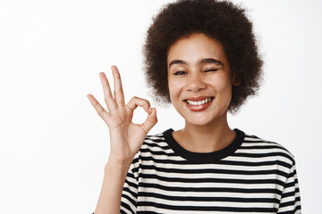 Portrait of beautiful black girl showing zero, okay sign, complimenting, recommending product, like...