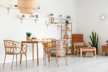 Interior of light dining room with wicker chairs and table