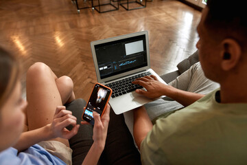 Blogger couple editing video on digital devices