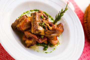 Appetizing baked rabbit meat with garlic served with potatoes on plate