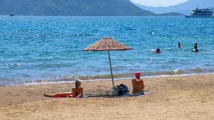 People are resting on the beach by the sea. Marmaris Turkey August 2021