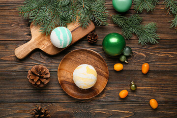 Composition with bath bomb, kumquat fruits, Christmas balls and fir branches on wooden background