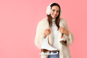 Happy woman in winter clothes and with ice skates on color background