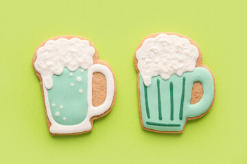Tasty decorative gingerbread cookies for St. Patrick's Day celebration on green background