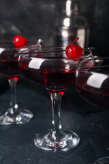 Glasses of tasty Manhattan cocktail on black background