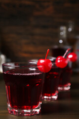 Glasses of tasty Manhattan cocktail on dark wooden background