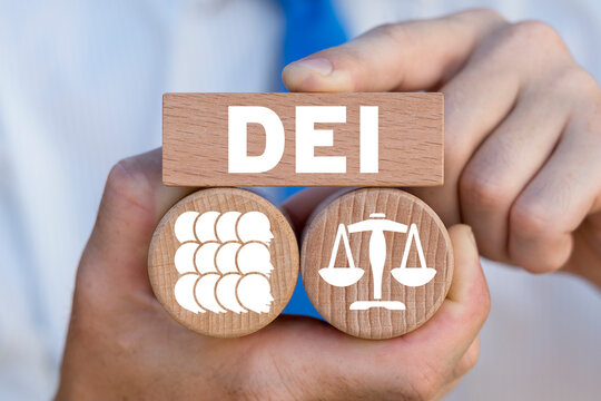Concept of DEI Diversity Equality Inclusion. Multiracial Multicultural Community. Man holding wooden blocks with abbreviation a DEI - Diversity Equity Inclusion Belonging Human Rights.