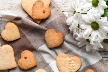 Fototapeta na wymiar Tasty heart shaped cookies and Chrysanthemum flowers on table. Valentines Day celebration