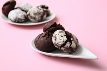 Plates with tasty chocolate brownie cookies on pink background
