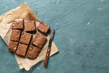 Pieces of tasty chocolate brownie on blue background