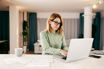 A businesswoman working online from her home on the laptop.