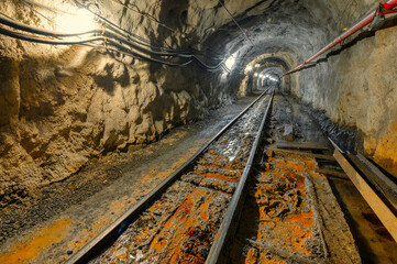 Fototapeta na wymiar Underground mine. Underground railway for transporting ore. Mine trolley as part of an underground freight train