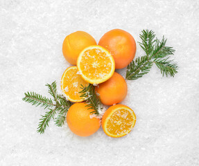 Fresh oranges and fir branches on snow