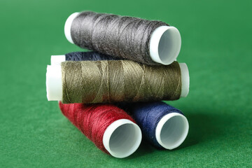 Multicolored sewing thread spools on color background