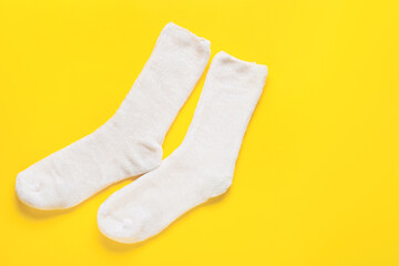 Pair of white socks on yellow background