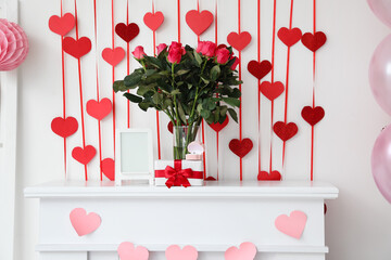 Bouquet of flowers, blank photo frame, gift box and engagement ring on mantelpiece near light wall