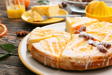 Plate with tasty citrus cake with oranges on table