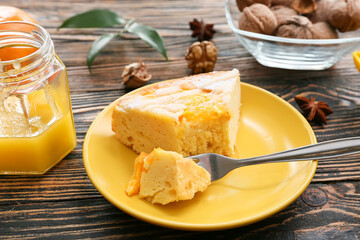 Plate with slice of tasty citrus cake with oranges on table