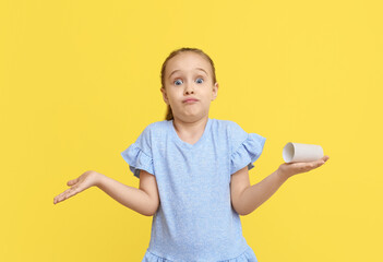 Confused little girl out of toilet paper on yellow background