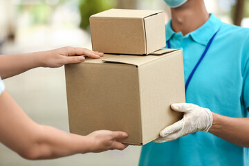 Young woman receiving parcels from courier of delivery company