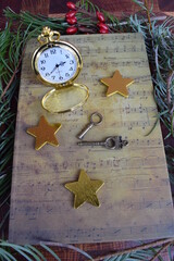 Still life pocket watch with vintage keys, gold stars and music book.