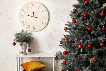 Stylish interior with Christmas tree and wooden clock on light wall
