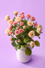Vase with bouquet of beautiful roses on purple background