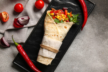 Plate with delicious burrito and vegetables on grey background - obrazy, fototapety, plakaty