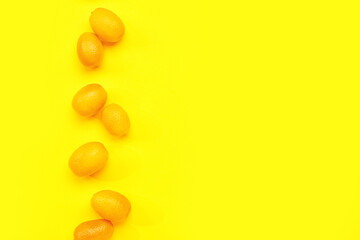 Fototapeta na wymiar Tasty kumquat fruits on yellow background