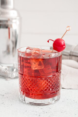 Glass of iced Manhattan cocktail on light background, closeup