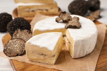 Soft cheese and fresh truffles on table, closeup