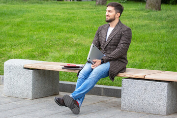 Obraz premium successful businessman resting on a city bench after a completed work project