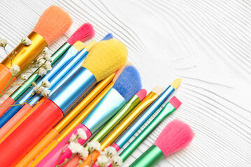 Fototapeta premium Set of makeup brushes on light wooden background, closeup