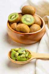 Bowl with fresh kiwi on light background