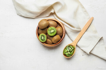 Bowl with fresh kiwi on light background