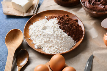 Plate with flour and cocoa powder for preparing chocolate brownie on table