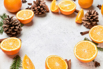 Frame made of fresh oranges and pine cones on light background - Powered by Adobe