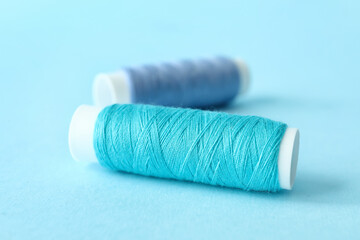 Blue sewing thread spools on color background