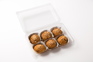 Baked Walnut Breakfast Muffins in a Plastic Container on a White Background