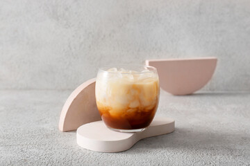 Glass of White Russian cocktail on light background