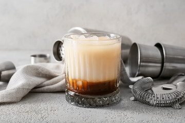Glass of White Russian cocktail on light background