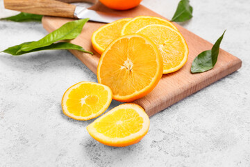 Wooden board with slices of juicy orange on light background