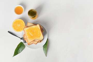 Toasts with tasty orange jam on light background