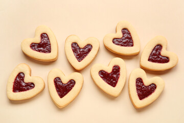 Tasty cookies in heart shape on beige background