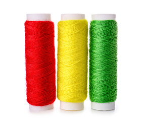 Different sewing thread spools on white background