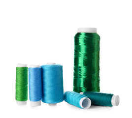 Different sewing thread spools on white background