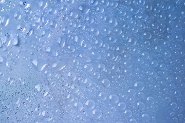 Water drop background on abstract blur blue clear glass surface